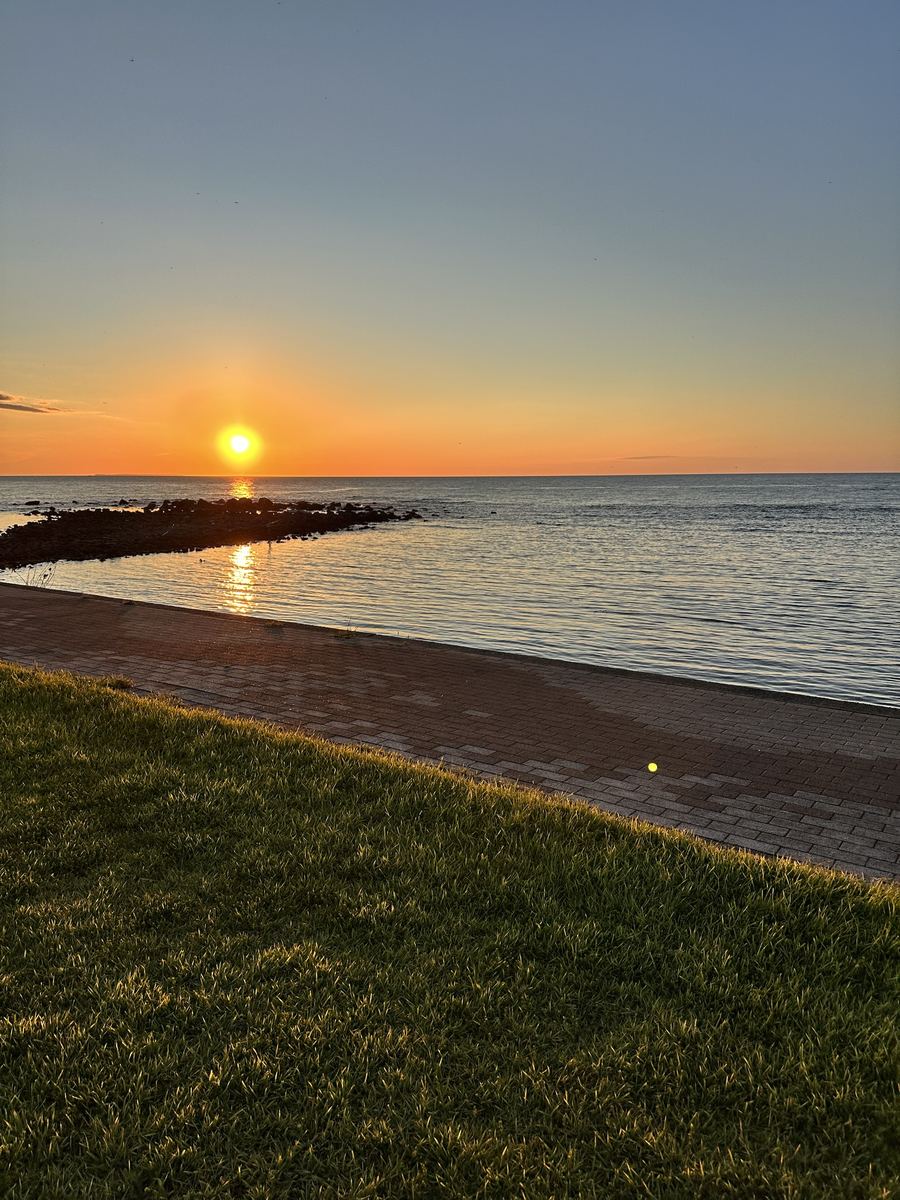 海のどまんなかに夕日。岩場の影まで橙に染まった。