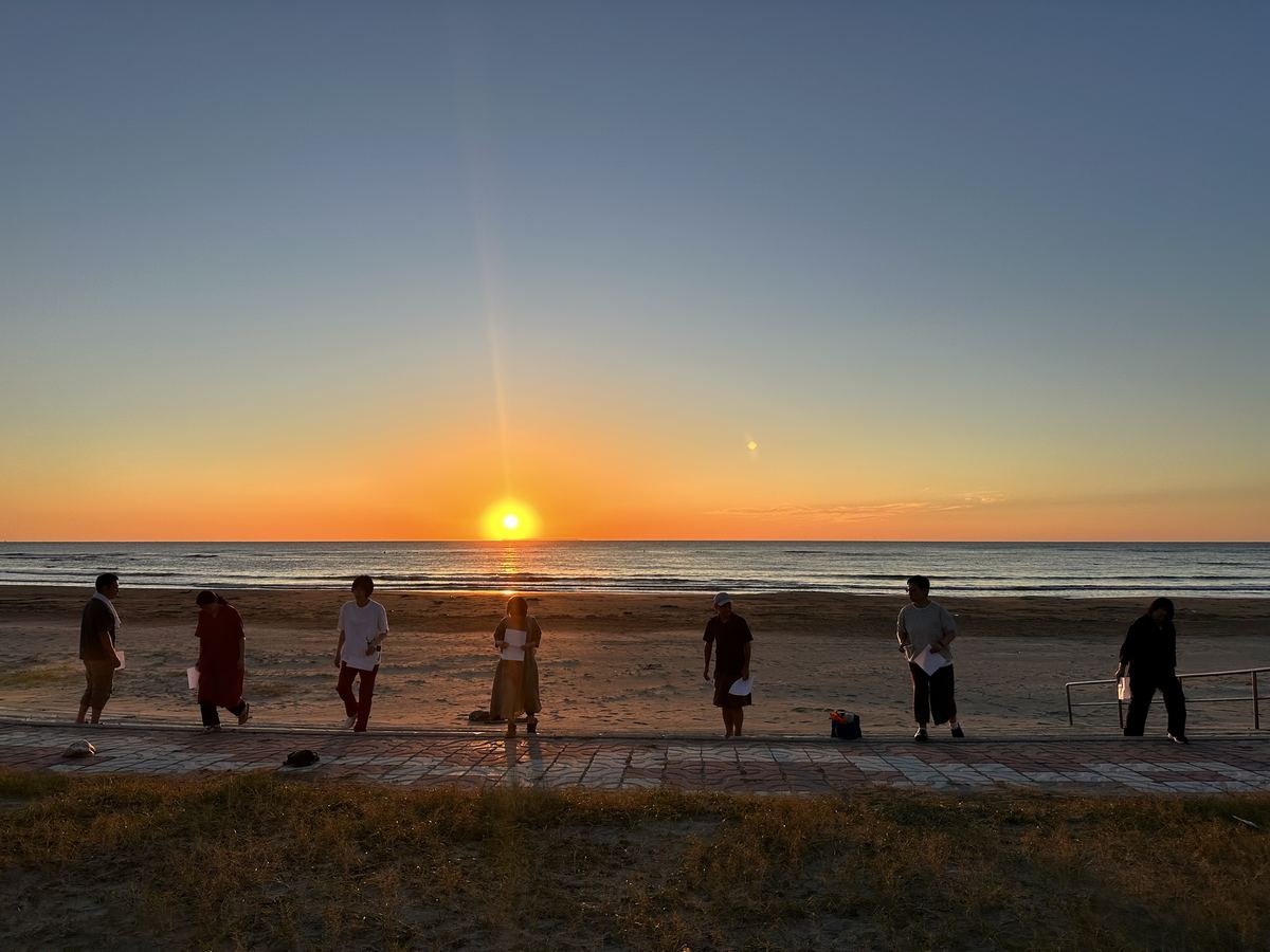 明日の山の歩き方を、浜で稽古。太陽が水平線に触れて、光の道がみんなの足もとまで来とった。